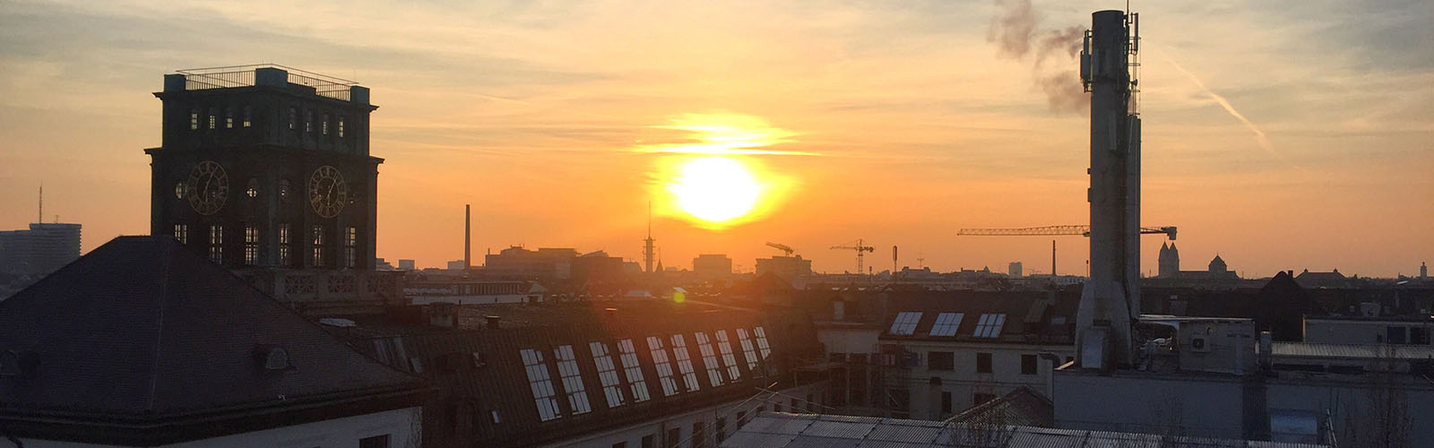 Sunset over Munich. The sun is casting a dark shadow over the city.